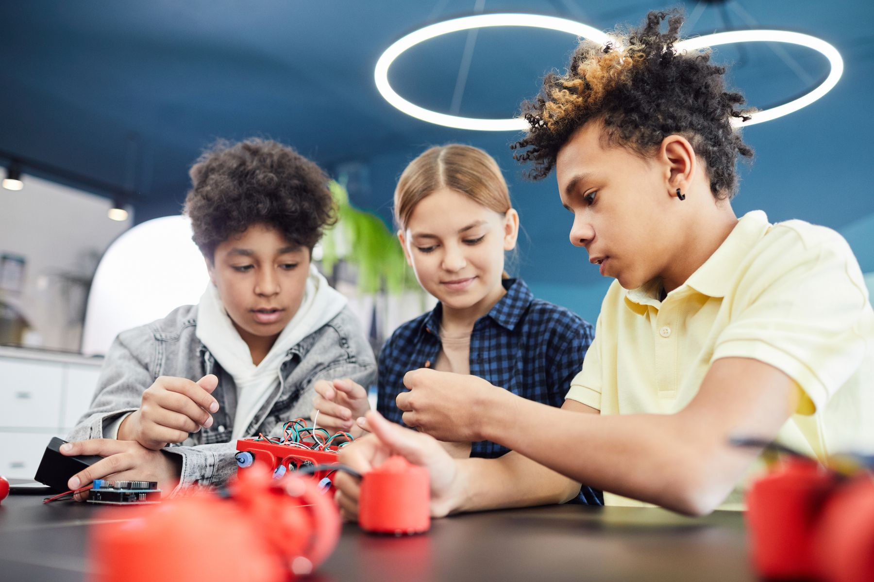 Students building a robotics project together in a workshop